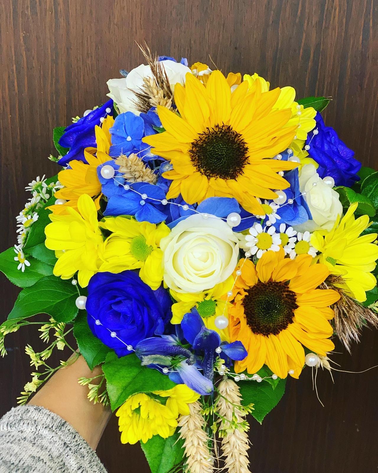 Brautstrauß mit Sonnenblumen, weißen Rosen und blauen Blüten