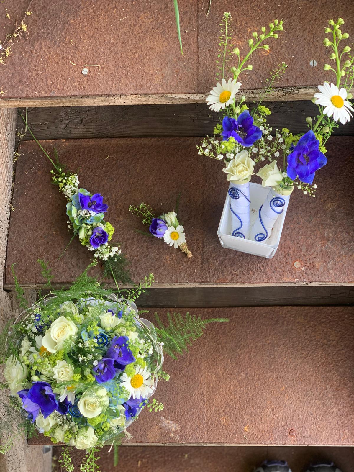 Hochzeitsarrangements mit weißen, gelben und blauen Blüten