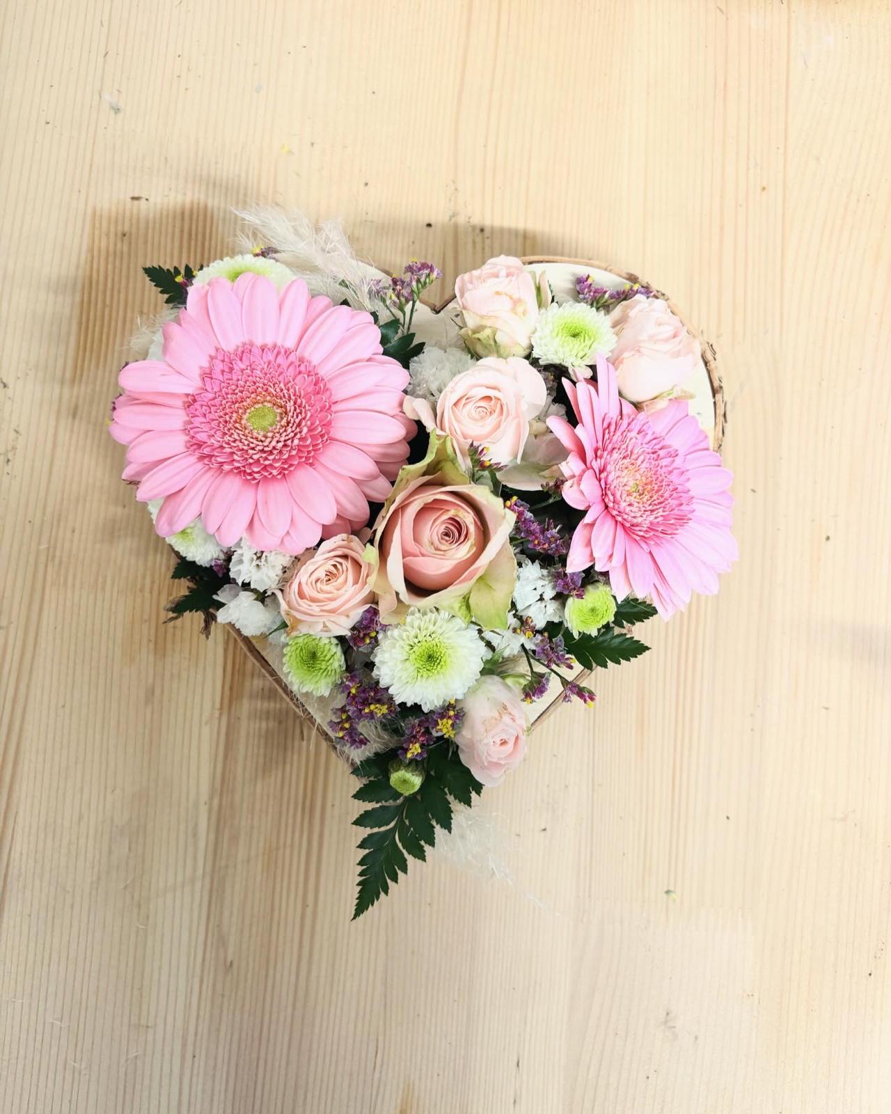 Herzförmiger Blumengruß mit rosa Gerbera und weißen Blüten