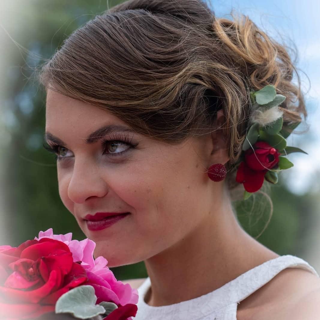 Rote Rosen und Eukalyptus als floraler Haarschmuck einer Braut
