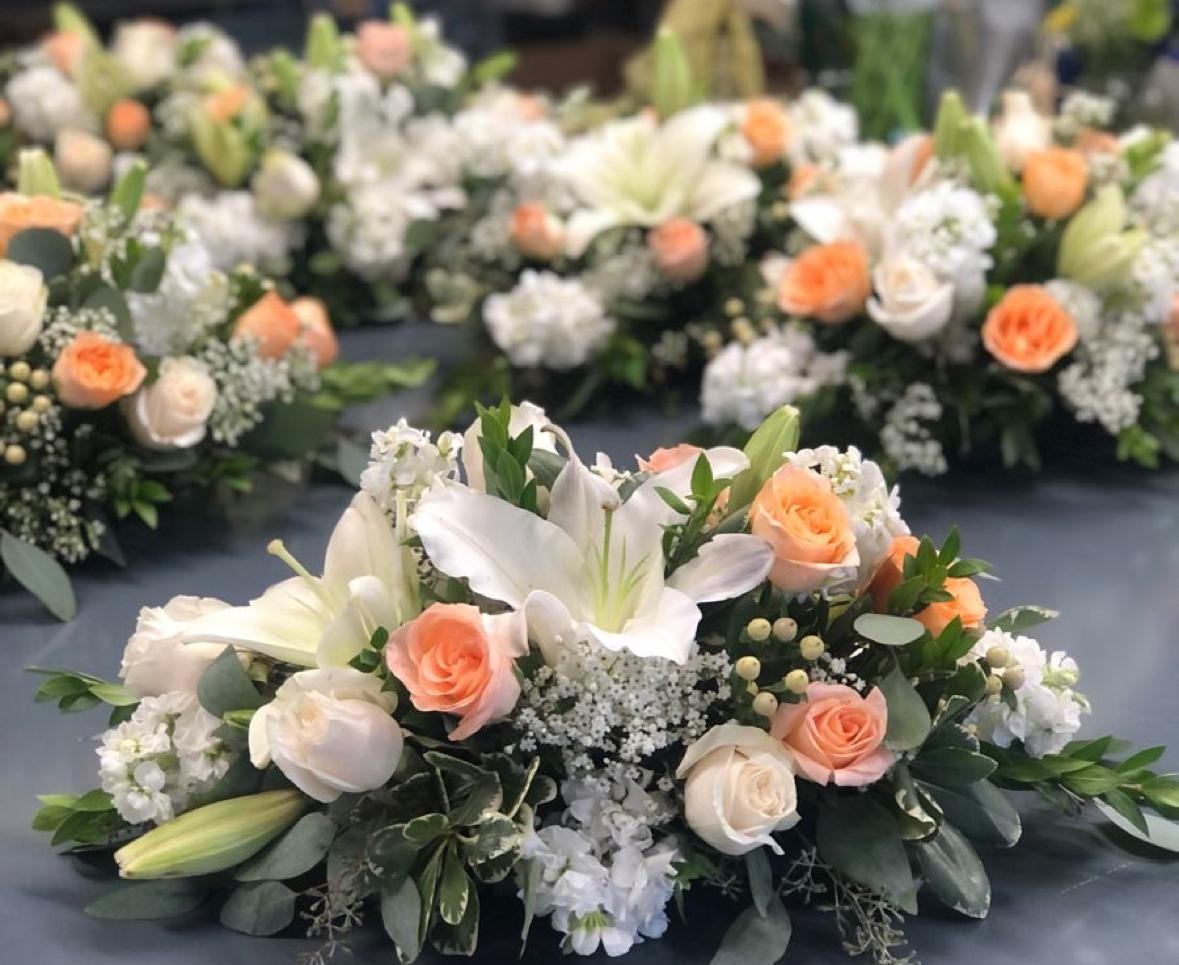 Tischgestecke mit weißen Lilien und Rosen in Apricot